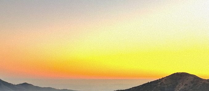 Sunset view over rolling hills and ocean horizon